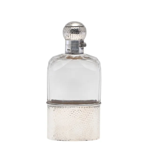 AN EDWARDIAN SILVER MOUNTED GLASS FLASK.
