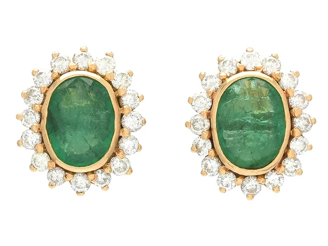 CARMOSÉÖRHÄNGEN, 18K guld, ovalslipade smaragder ca 1,90 ctv, 32 briljantslipade diamanter ca 0,96 ctv, ca W/VS-P, stift, höjd 15 mm, vikt 6,1 g, smaragderna med nagg och ytsprickor, en diamant är skadad.