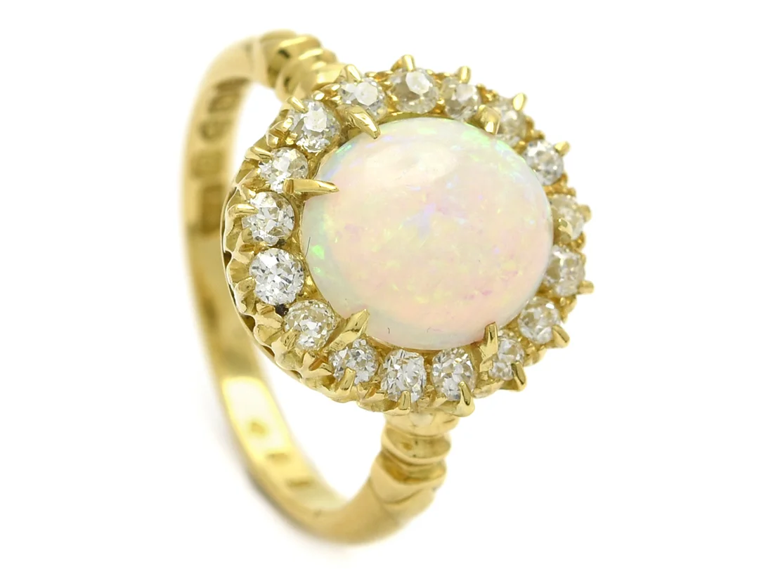 CARMOSÉRING, 18K guld, Opal, 17 gammalslipade diamanter ca 0,50 ctv, ca TW-W/VS, England Chester, stl 17,75 mm, vikt 5,4 g, opal något lös i fattningen, en diamant skadad, en med nagg. — Smycken/Carmoséring — Kaplans