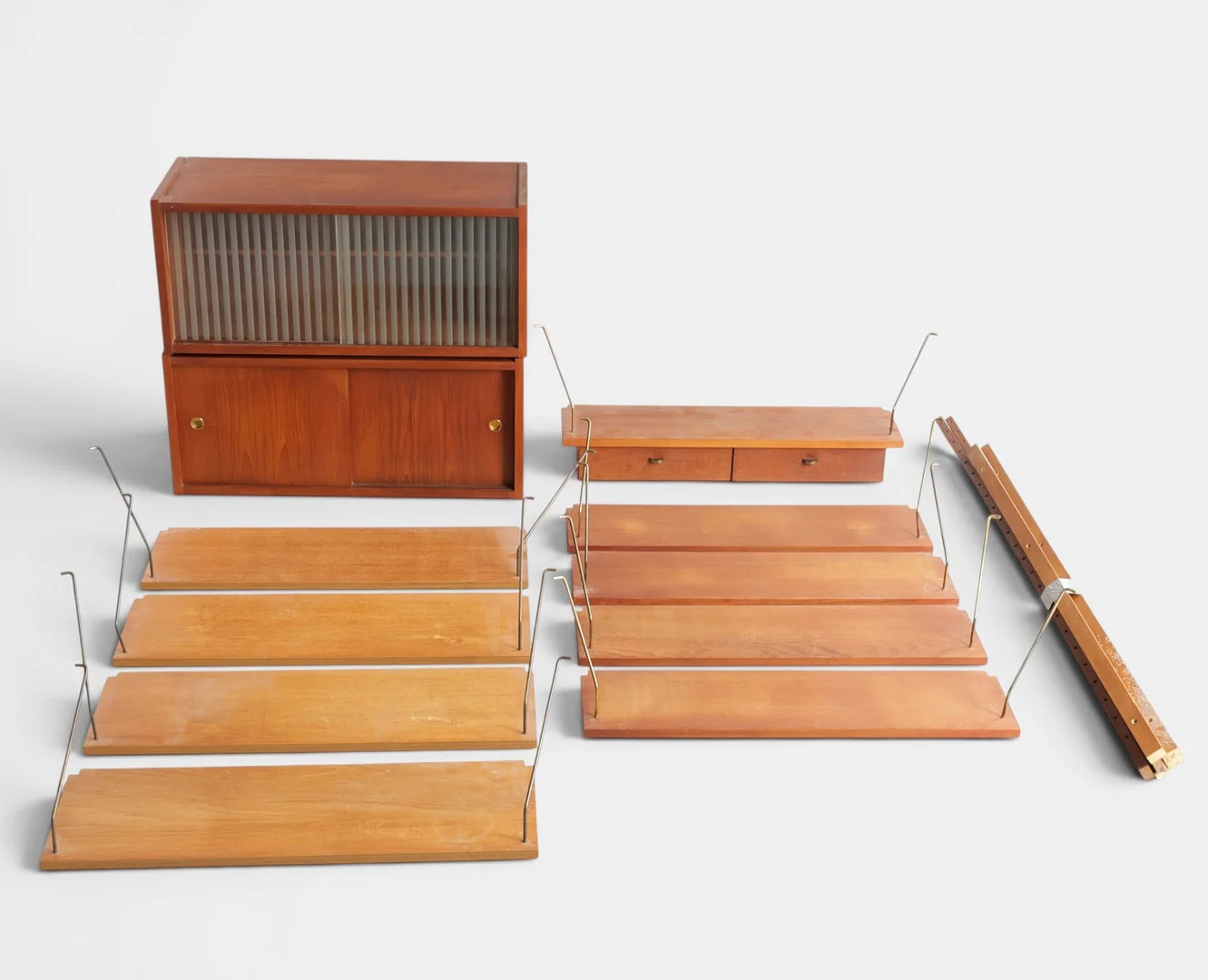 PREBEN SØRENSEN. "PS System", væghængt reolsystem af teak. Udført hos PS System, Randers. Danmark, 1960'erne (17). — Cupboards, Cabinets & Shelves — Woxholt Auktioner