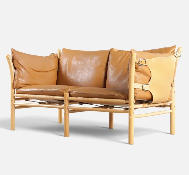 ARNE NORELL. “Ilona”, fritstående to-personers sofa af bøg, udspændt med stropper og sider af kernelæder, løse hynder betrukket med cognacfarvet skind. Formgivet 1971. Udført og mærket hos Norell. Sverige, 1960-70'erne.