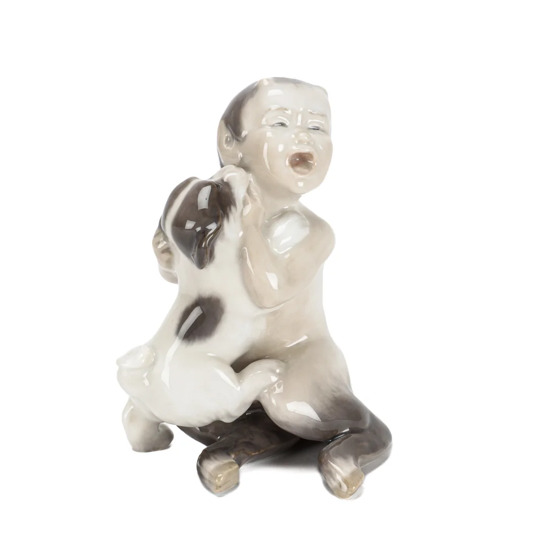 Christian Thomsen for Royal Copenhagen. Faun with puppy figurine no. 2823 1 black. — Glass, porcelain and ceramics/Figures — Lauritz