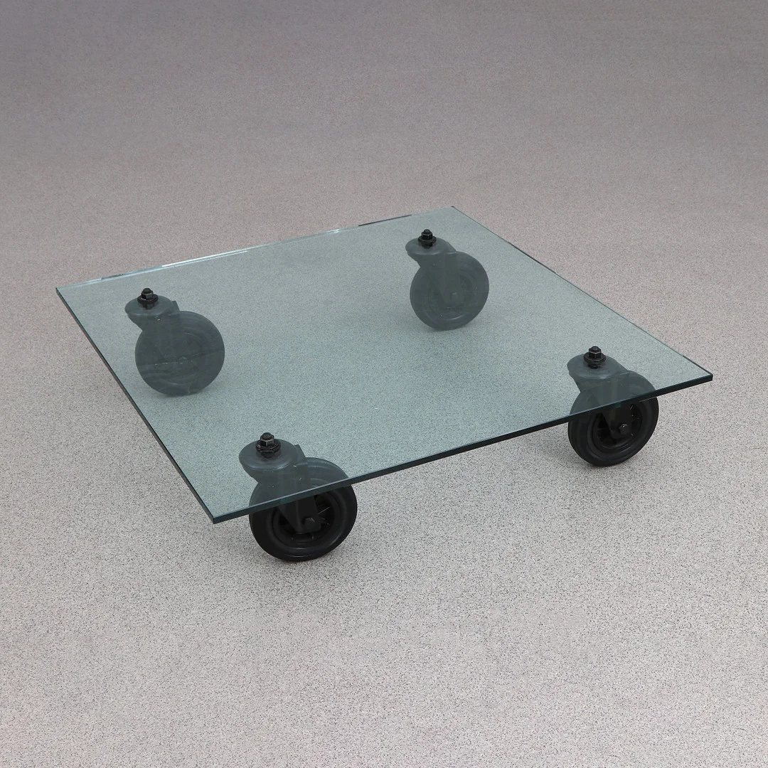 GAE AULENTI. SOFFBORD. Glasskiva på hjul. "Tavolo Con Ruote". — Tables — Skånes Auktionsverk