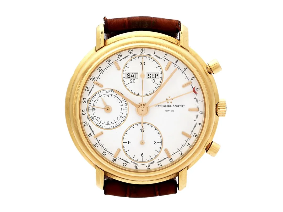 ETERNA-MATIC, Chrono-Matic (Swiss), Cal ETA 7751, Serie nr. 046, Boett nr. 678.8401.68, kronograf, herrur, 37,5 mm, 18K guld, automatisk, safirglas, dag, datum, månad, 24-timmarsvisning, läderband, ca 1992. — Klockor/Eterna — Kaplans