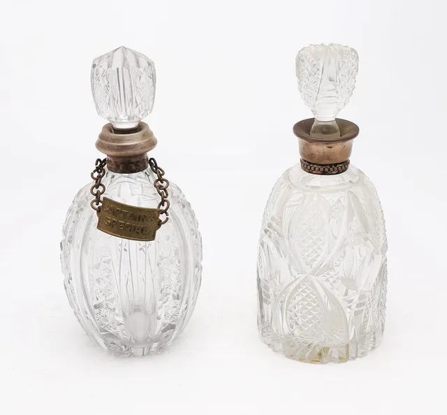 Two decanters in carved glass with silver mounts, 20th Century.
