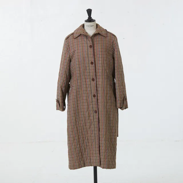 CELINE, kappa med löstagbar väst och skärp, quiltad, rutig med passpoaler och knappar i läder, uppskattad storlek 38, etikettmärkt Celine Paris Marque Deposées Made in France.