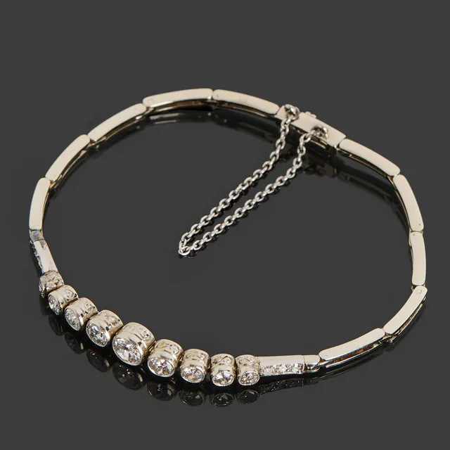 ARMBAND, Art Deco, 18k vitguld, halvledad länk dekorerat med 15 st briljantslipade diamanter totalt ca 1.20ct, millegriffdekor, 1932, Guldvaruaktiebolaget G. Dahlgren & Co Ab, Malmö.