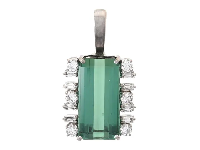 HÄNGE, låghaltigt vitguld, smaragdslipad grön turmalin, 14 briljant- och baguetteslipade diamanter ca 0,80 ctv, ca TW-W/VS-SI, höjd på hänget 29 mm, vikt 6,5 g, turmalinen sitter löst i fattningen, 1 diamant med nagg på kuletten, hänget är ej stämplat.