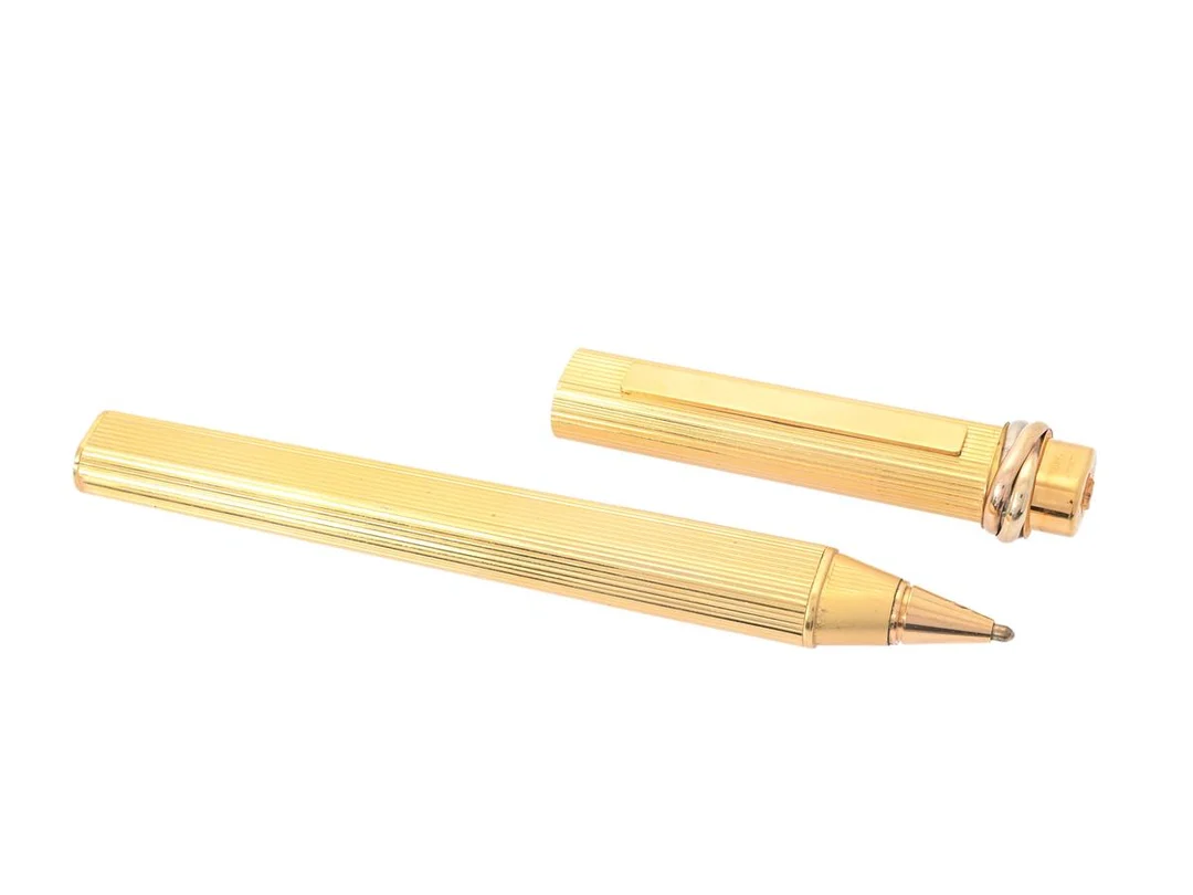 CARTIER, kulspetspenna, guldpläterad metall, Trinity, märkt 063168, längd 13 cm, slitage, ej funktionstestad. — Accessoarer/Pennor — Kaplans
