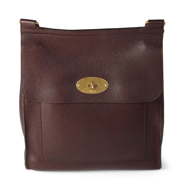 “Anthony” bag of burgundy/purple leather with gold tone hardware, adjustable shoulder strap, turn lock, one front pocket and one compartment. H. 30 x W. 29 x D. 8 cm.