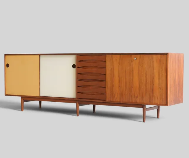 ARNE VODDER. “Credenza”, skulpturel fritstående skænk af palisander, front med to vendbare skydelåger, ene side med palisander, ene side med hhv. gul og hvid bemaling, centralt med skuffer, side med nedfældig klap. Udført og mærket hos P. Olsen Sibast, model 29A.