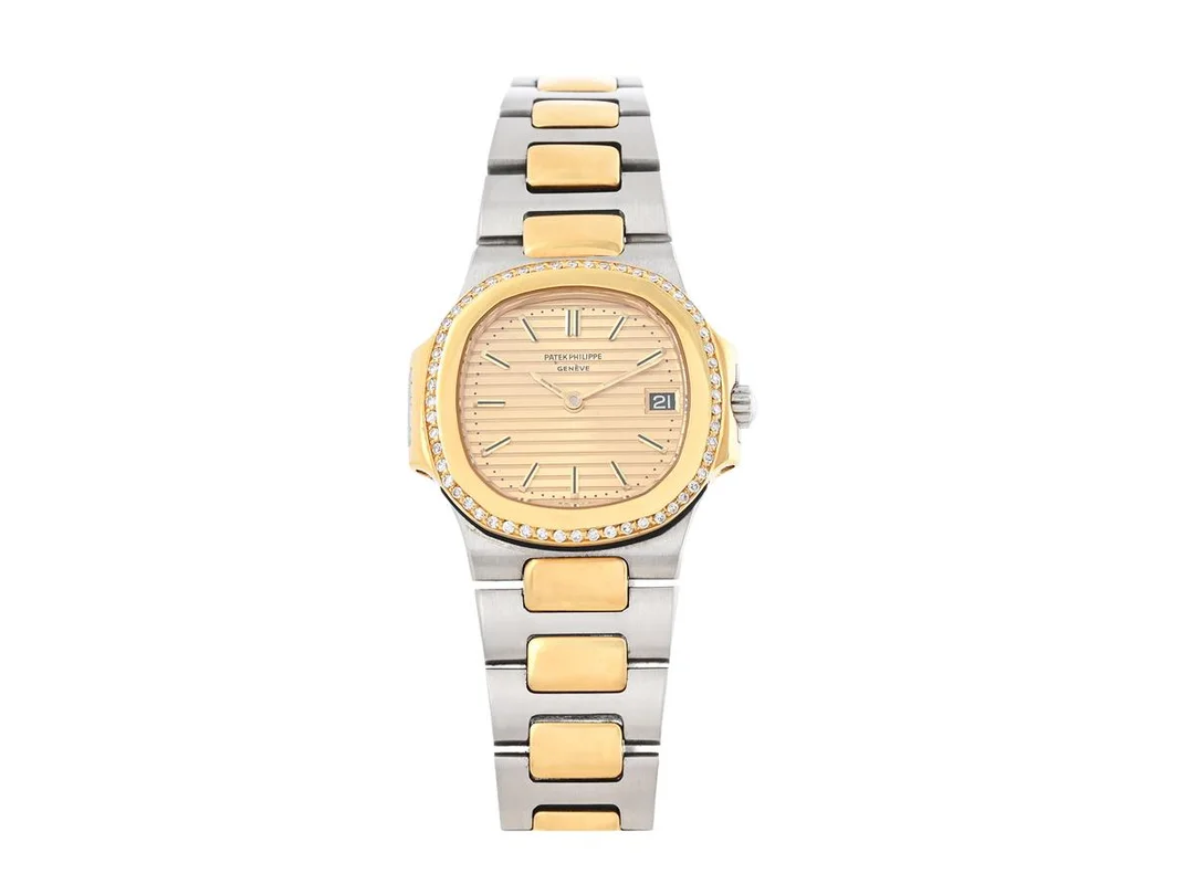 PATEK PHILIPPE, Nautilus, Cal E19 C, Serie nr. 1525712, Ref nr. 4700/2, Boett nr. 2797436, damur, 27 mm, stål/guld, quartz, safirglas (repor), datum, diamantkrans (56 st. 8/8, TW/VS, ca 0,40 ctv), integrerad originallänk (längd 145 mm), viklås, ca 1990. — Klockor/Patek Philippe — Kaplans