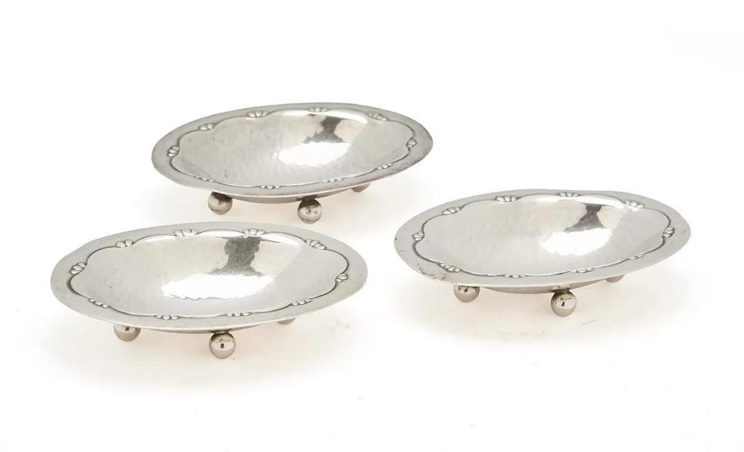 Three oval sterling silver salt cellars with round feet and foliage decor. Georg Jensen 1904–1908. Design no. 243 C. Total weight 73 g. H. 1.6 cm. W. 5.6 cm. L. 8.2 cm. (3) — Silver/Georg Jensen — Bruun Rasmussen