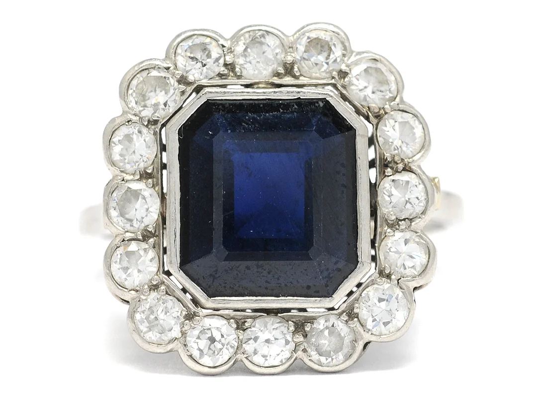CARMOSÉRING, platina, safir ca 4,50 ct, 16 medium- och gammalslipade diamanter ca 0,80 ctv, ca TW-W/VS, fyra stenar skadade, stl 19 mm, vikt 6 g. — Smycken/Carmoséring — Kaplans