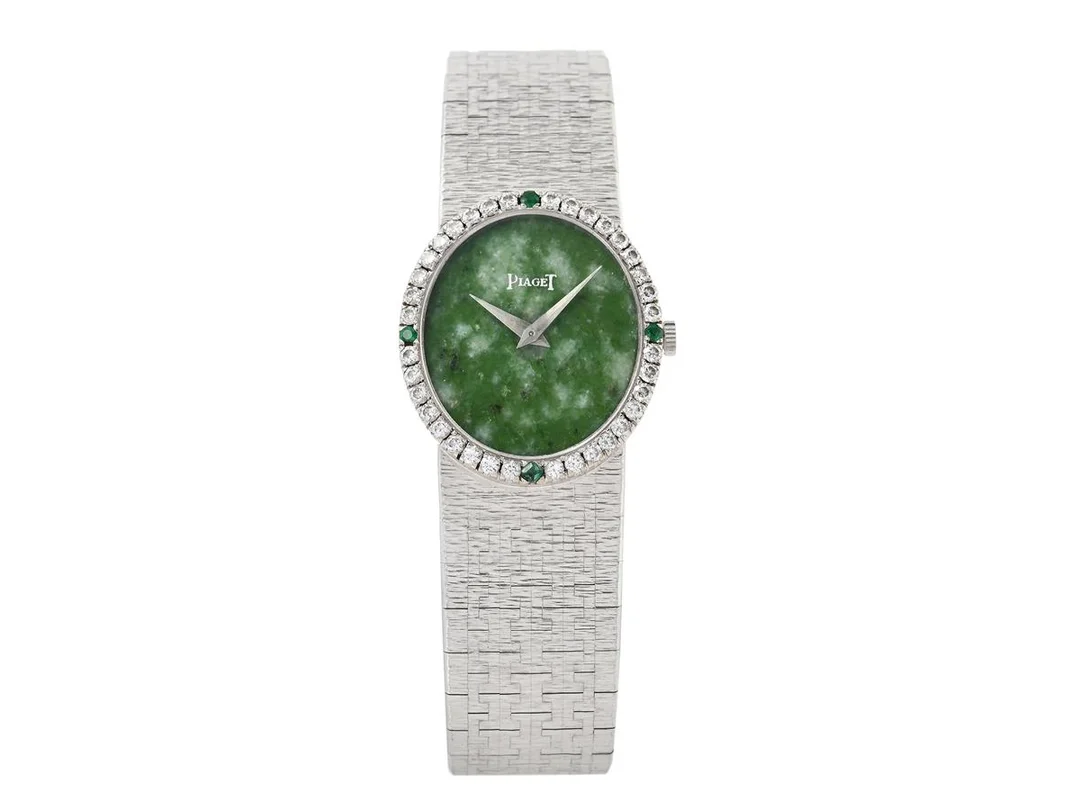 PIAGET, damur, "Jade Dial", 24 x 32 mm, Cal 9P, Serie nr. 6907559, Ref nr. 9826 A6, Boett nr. 176915 / 90, 18K vitguld, manuell, safirglas, urtavla i jade, briljantkrans (36 st. briljantslipade diamanter, ca TW/VVS, ca 0,64 ctv + 4 st gröna ädelstenar), integrerad originallänk, längd 183 mm, totalvikt 65,8 gram, ca 1970. — Klockor/Piaget — Kaplans