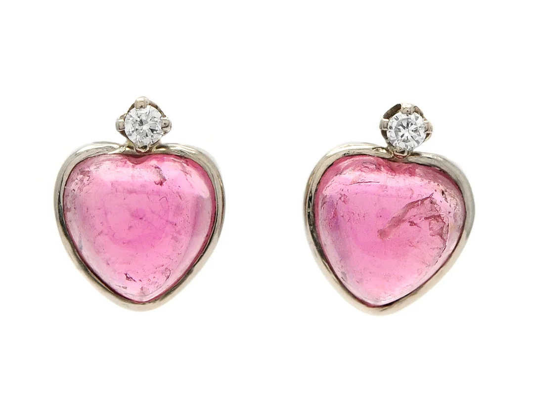 ÖRHÄNGEN, 18K vitguld, 2 cabochonslipade, hjärtformade rosa turmaliner ca 3,20 ctv, ena turmalinen har inneslutning som når ytan, 2 briljanter ca 0,06 ctv, ca TCr/VS, stift, vikt 2,5 g. — Smycken/Örhängen — Kaplans