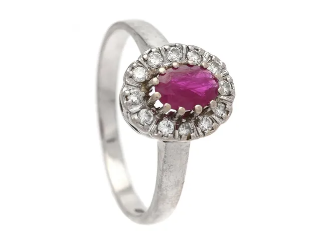 CARMOSÉRING, 14K vitguld, ovalslipad rubin, 12 briljantslipade diamanter ca 0,18 ctv, ca W/VS, stl 17,5 mm, vikt 2,5 g.