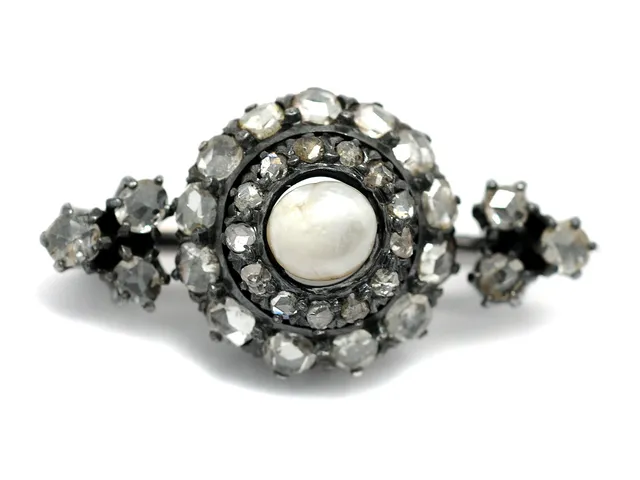 BROSCH, 18K guld/silver, orientalisk pärla, 32 rosenslipade diamanter, flera med skador, mått 3 x 1,5 cm.
