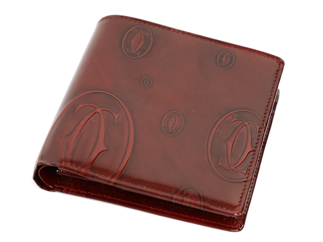 PLÅNBOK, CARTIER, vinröd skinnlack, 10x10 cm, mynt, sedel, 4 st kontokortsfack, certifikat samt originalask. — Accessoarer/Plånböcker — Kaplans