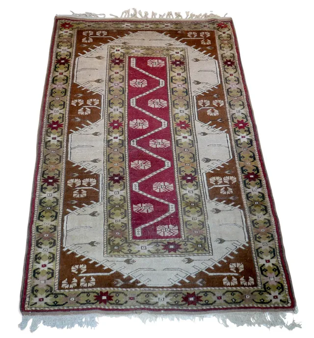 A HAND KNOTTED WOOLEN RUG.