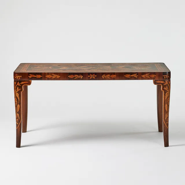 CARL MALMSTEN. Biblioteksbord, 1935, jakaranda med intarsia dekor i valnöt, mahogny, lönn, med flera träslag, dekor av blad och blom dekor, runt om en fris med blomsterdekor.
