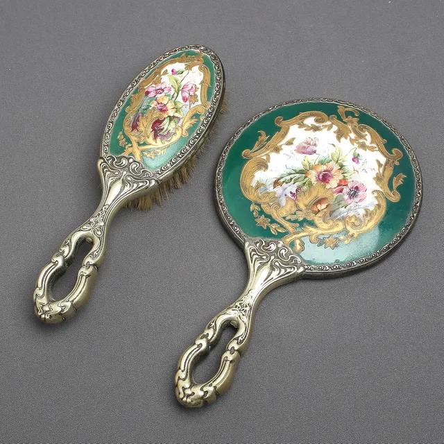 HANDSPEGEL samt BORSTE, nysilver och porslin med målad dekor, 1900-talets början.