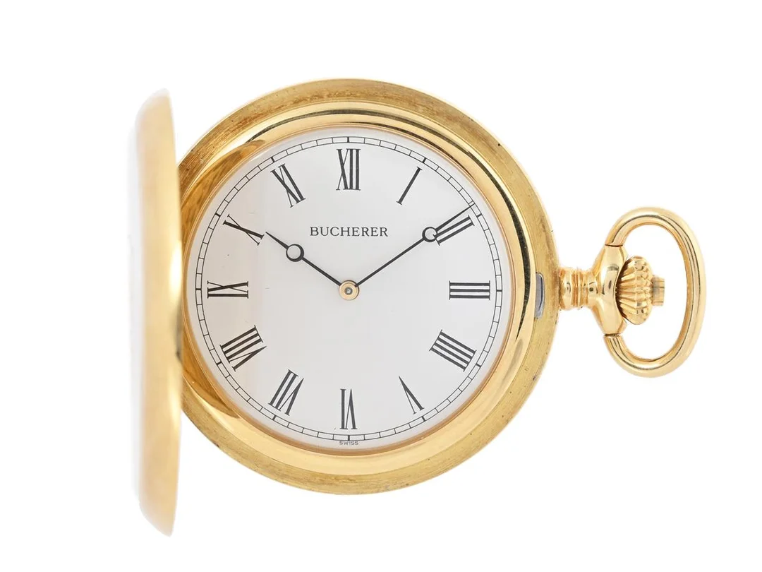 BUCHERER, fickur, 47 mm, savonett, Cal 952 (IWC), Serie nr. 2314698, Boett nr. 7775 5 / 952511, 18K guld, ankargång, urverk signerad International Watch Co, monogram, bucklor, ca 1975, läderpåse, etui (Bucherer). — Klockor/Bucherer — Kaplans