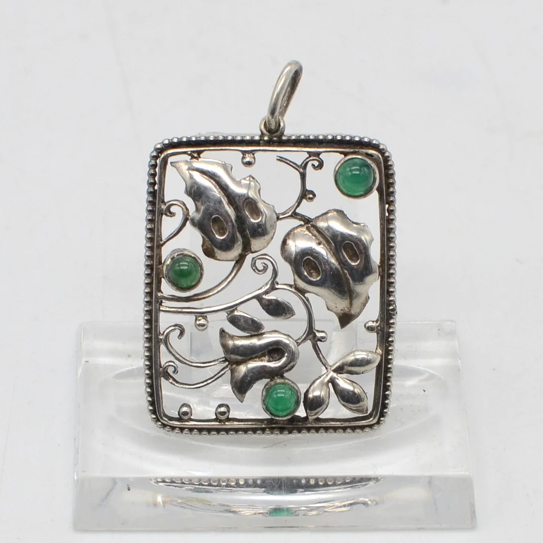 THEODOR FAHRNER. DURCHBROCHENER COLLIERANHÄNGER, GRÜNE FARBSTEINCABOCHONE, FASSUNG AUS 800ER SILBER, UM 1900. — Brooches & Pendants — Kunst- und Auktionshaus Kleinhenz