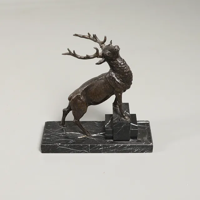 AN ART DECO SPELTER SCULPTURE OF A WOUNDED STAG.