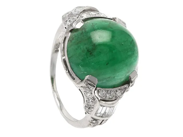 RING, platina, cabochonslipad smaragd ca 6,50 ct, baguette- och åttkantslipade diamanter ca 0,45 ctv, Art Deco, stl 16 mm, vikt 5,4 g, graverad, spricka i lödning, smaragden har inneslutningar som når ytan, några diamanter har skador och nagg.