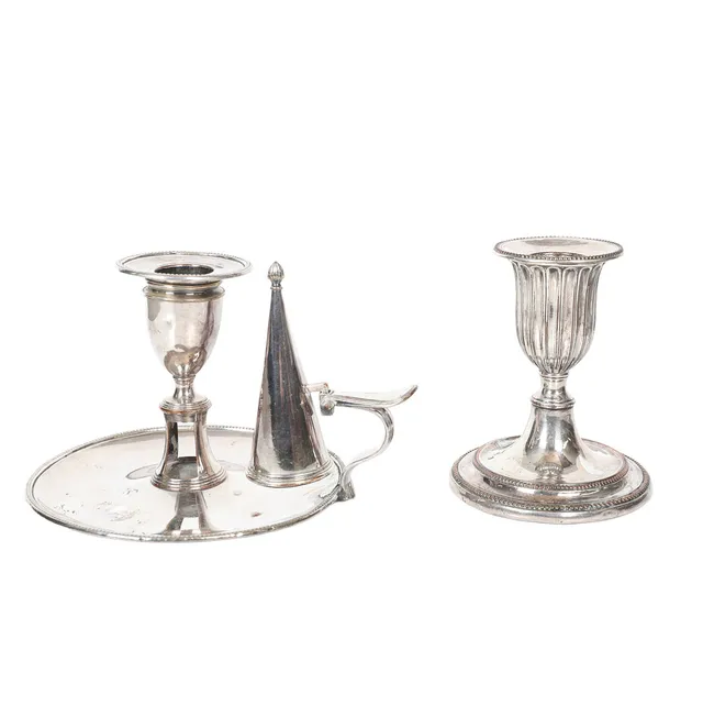 A GEORGE III SHEFFIELD PLATE CHAMBERSTICK TOGETHER WITH A CANDLESTICK (2).