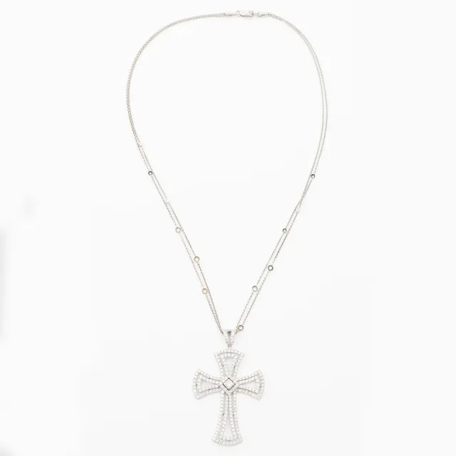 Hänge i form av kors, vitguld och med prinsess och briljantslipade diamanter.