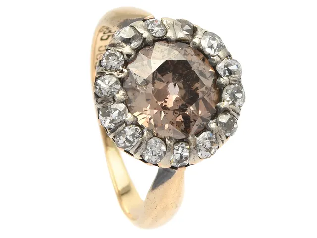 RING, 14K guld, gammalslipad diamant ca 1,75 ct, brun färgton, ca P1, 14 diamanter ca 0,50 ctv, stl 16,25 mm, vikt 3,3 g, skada på mittstenen, nagg och skador på de mindre diamanterna.