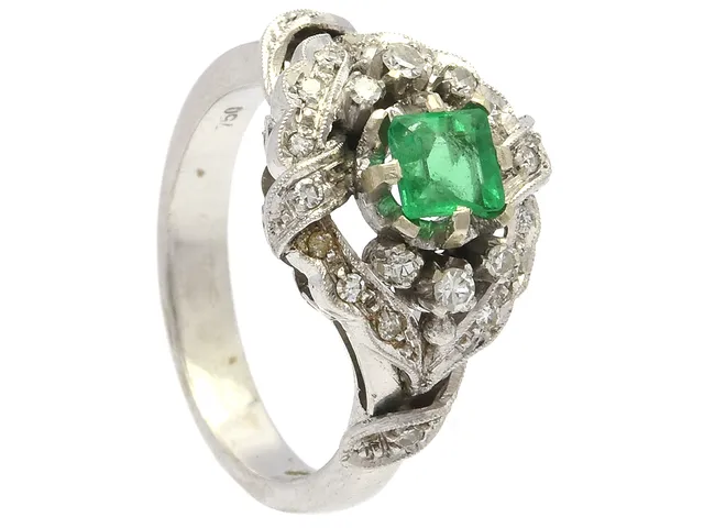 RING, 18K vitguld, smaragd, mindre skada på ett hörn, 22 åttkantslipade diamanter ca 0,25 ctv, stl 17 mm, vikt 6,6 g, svaga fattningar.