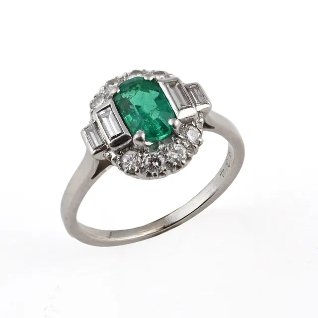 AN EMERALD AND DIAMOND CLUSTER RING.