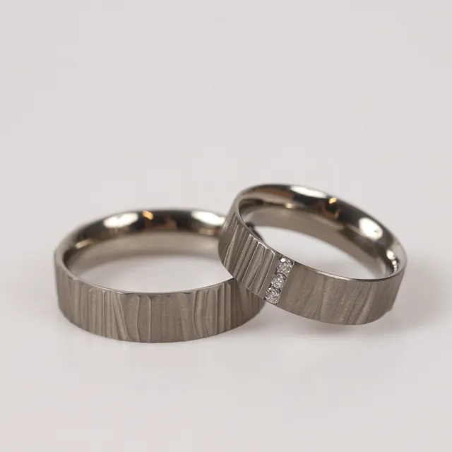 ALLIANSRINGAR, 2 stycken, titan med bl. a. briljantslipade diamanter, totalt 0,09 ct.