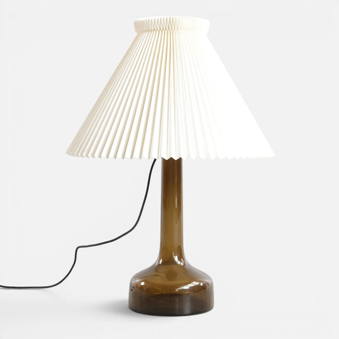 GUNNAR BIILMANN PETERSEN (F. FREDERIKSBERG , D. KØBENHAVN). Bordlampe af farvet glas med montering af messing, tilhørende plisseret skærm. Udført hos Le Klint, Danmark. — Table Lamps — Woxholt Auktioner