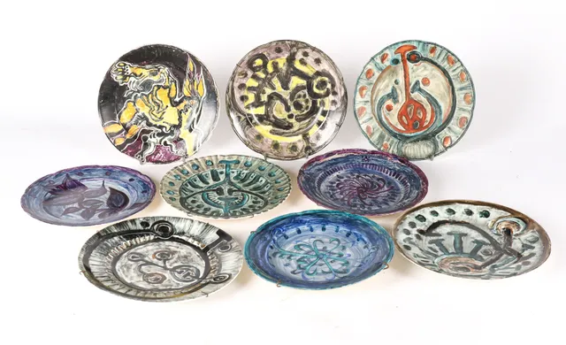 Nis Schmidt. Nine plates of faience and porcelain, decorated in colors. (9)