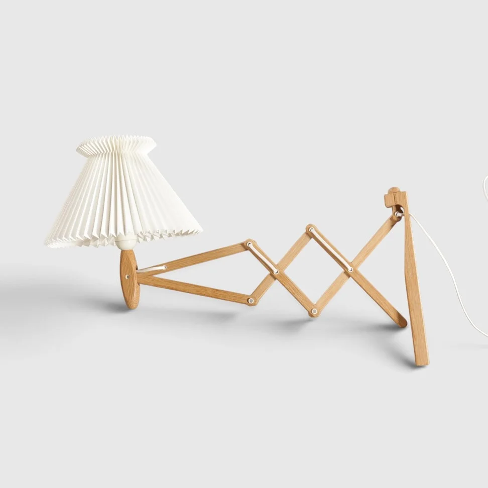 ERIK HANSEN. Væghængt sakselampe af massiv eg, monteret med plisseret skærm. Formgivet i 1952. Udført og mærket hos Le Klint, model '324/335'. Danmark. — Wall Lights — Woxholt Auktionshus