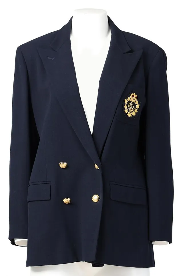 A navy blue wool blazer with an emblem motif and gold-toned buttons. Length: 76 cm. Sleeve length: 85 cm. Across chest: 42 cm. Size 42. (US12).