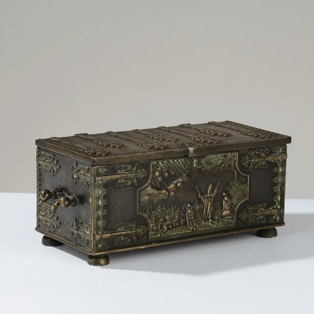 IRON ART COPENHAGEN: Bronzeskrin udformet som gammel kiste med smedejernsbeslag, dekoreret med motiv af Dannebrogs fald fra himlen i 1219, Danmark, 1900-tallets midte.