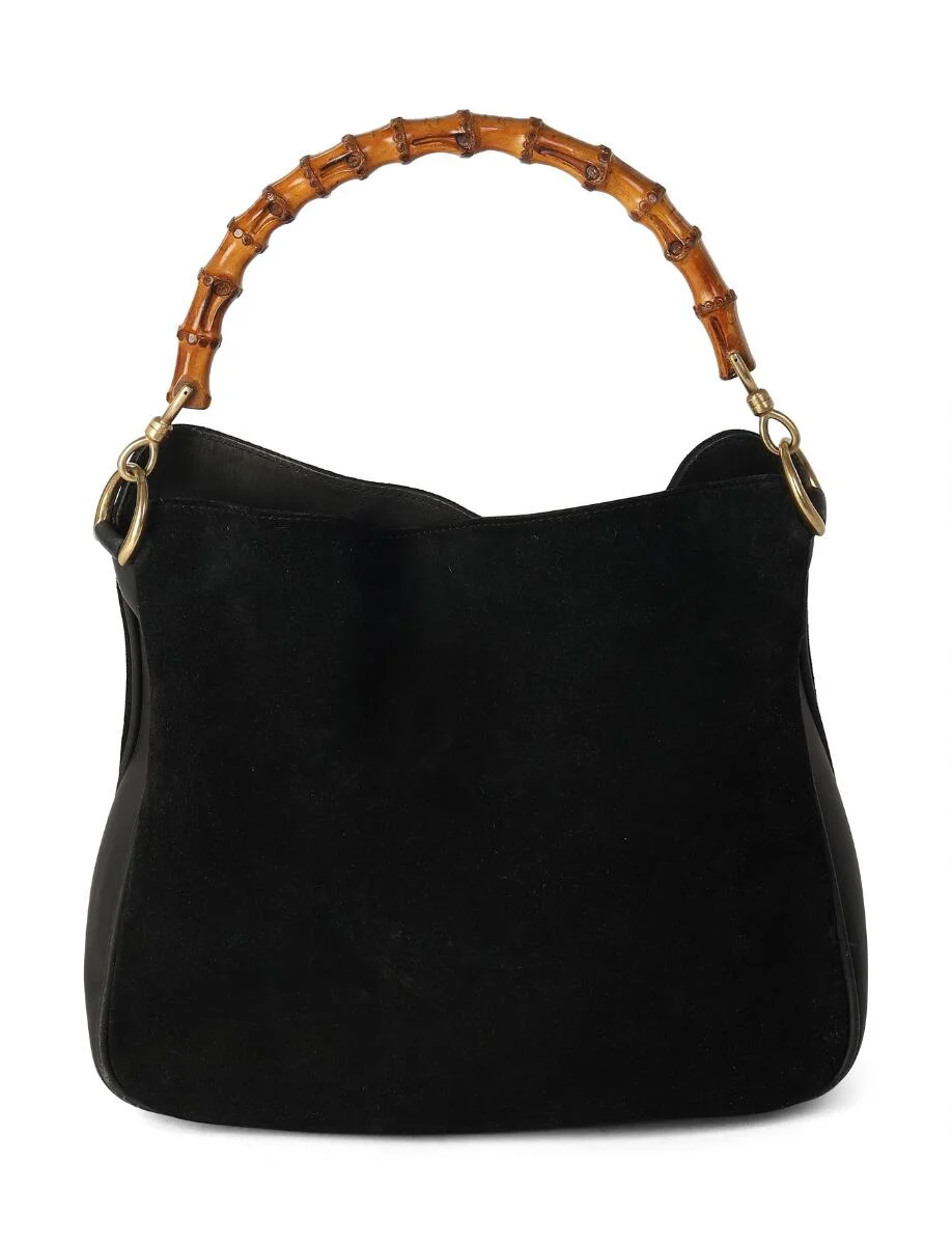 “Bamboo” bag in black suede and leather with a bamboo handle and gold-tone hardware, one compartment with a snap closure, one interior zip pocket, and black leather lining. H. 25 × W. 26 × D. 11 cm. — Designer Handbags & Fashion/Designer Handbags — Bruun Rasmussen