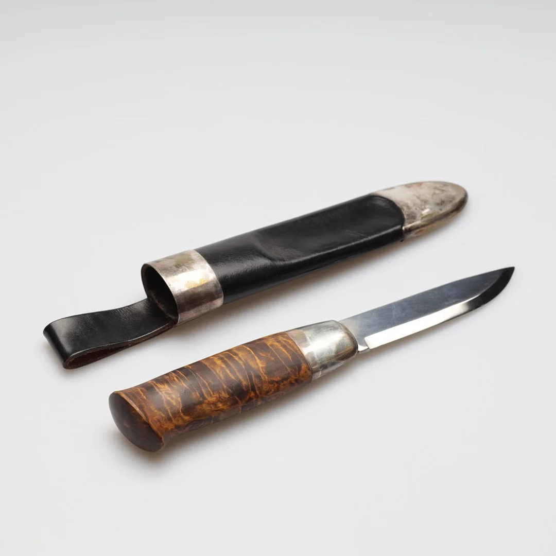 DAVID ANDERSEN. Kniv, "Peer Gynt-kniven", Norge, slida av läder och sterlingsilver, skaft av flambjörk. — Edged weapons — Gomér & Andersson Nyköping