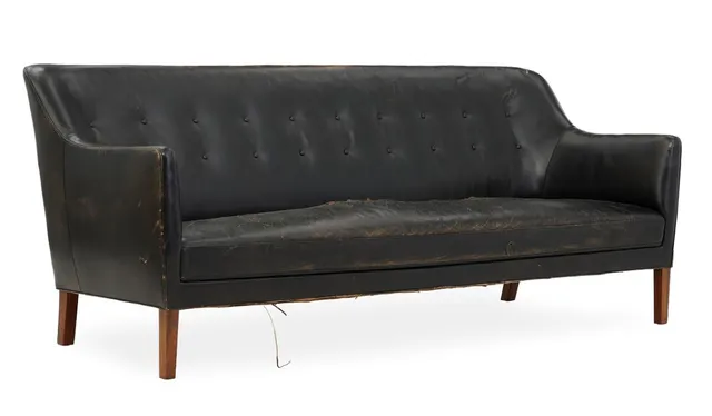 Fritstående tre-personers sofa med runde ben af rosewood. Sæde, sider samt dybthæftet ryg sort skind. Udført 1950'erne hos snedkermester Jacob Kjær. L. 210.