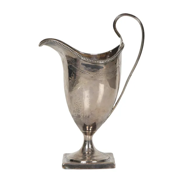 A GEORGE III SILVER CREAM JUG.