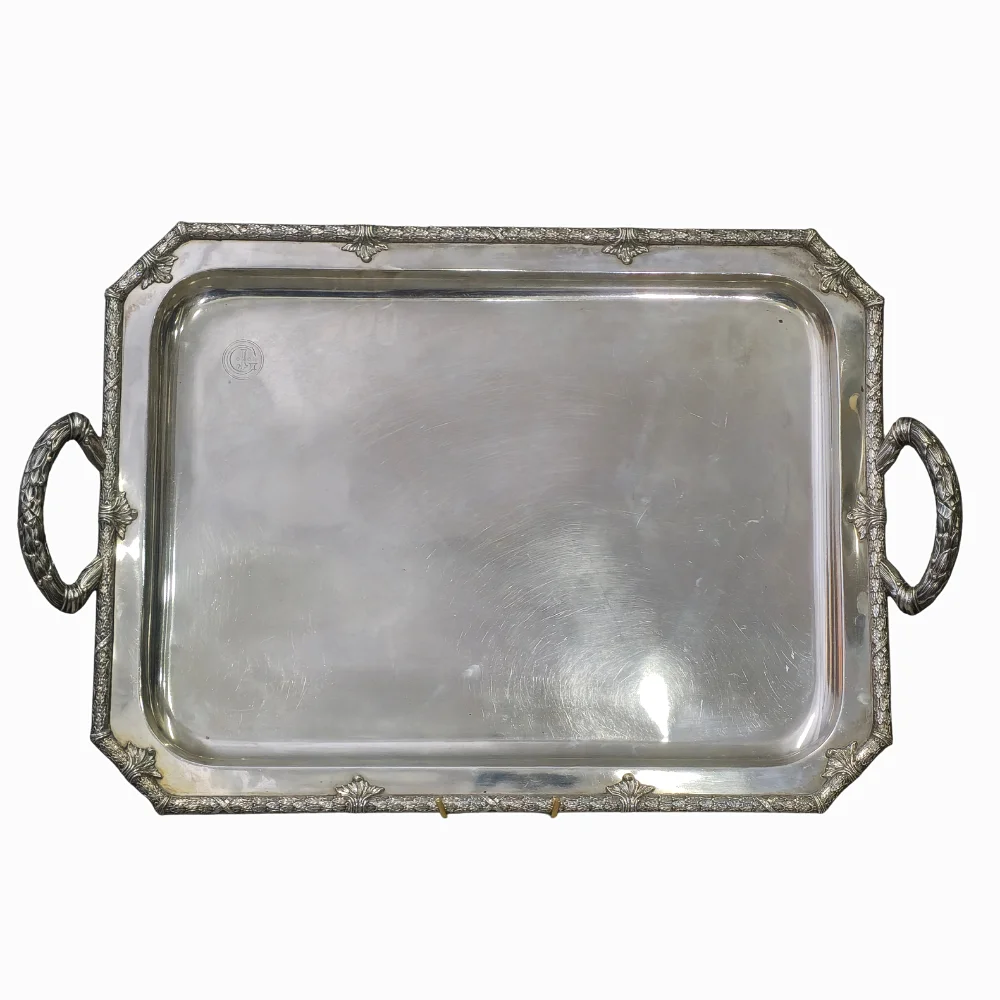 MASRIERA Y CARRERAS. Bandeja rectagular con doble asa en plata punzonada. Diseño perimetral decorado con guirnalda de laurel y anagrama "JG". — Silver — Barcelona Auctions
