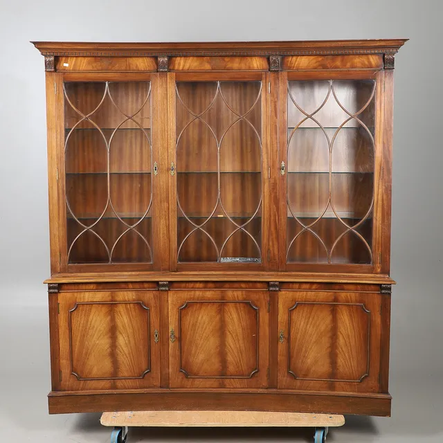 A RERPODUCTION MAHOGANY CONCAVE GLAZED BOOKCASE.