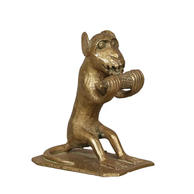A CAST BRASS MONKEY EATING CORN.