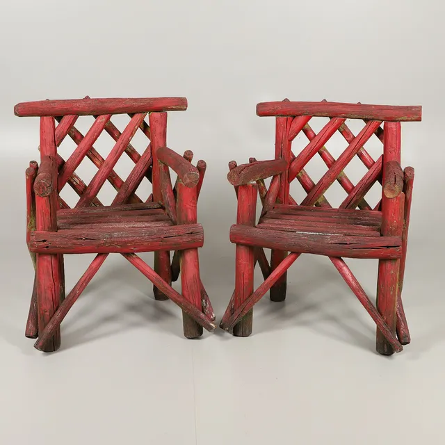 A PAIR OF RUSTIC RED PAINTED GARDEN CHAIRS.