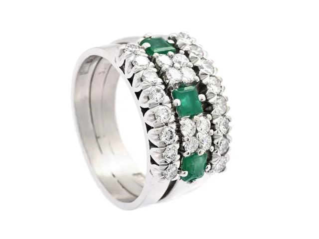 RING, 18K vitguld, carréslipade smaragder, briljantslipade diamanter ca 0,72 ctv, ca TW-W/VS-SI, stl 17 mm, vikt 9 g, flera diamanter har svaga fattningar, smaragder med nagg och inneslutningar som når ytan.